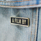 A Film by Credit Enamel Pin