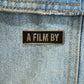 A Film by Credit Enamel Pin